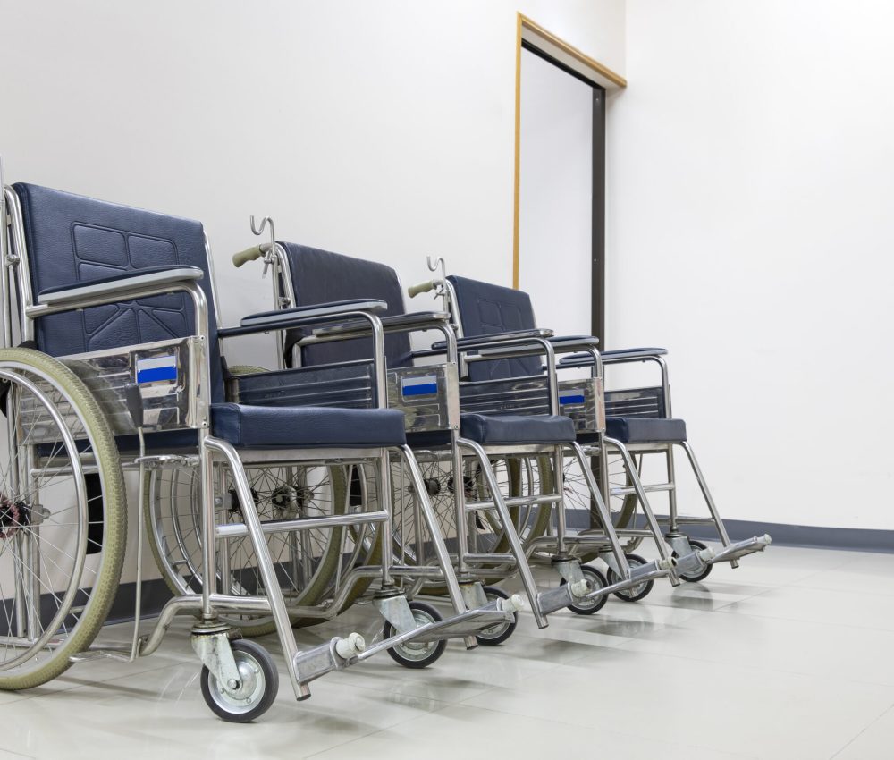 Three patient wheel chairs in a  clean and bright waiting area of a hospital. Out patient clinic image.